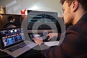 Young Man Composing Music on Laptop Computer in Bedroom