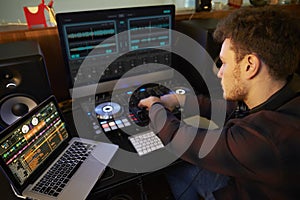 Young Man Composing Music on Laptop Computer in Bedroom photo