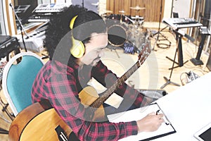 Young man composing song with clipboard photo