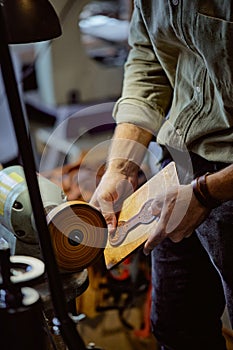 young man concentrated on working on electric burnishing tool photo