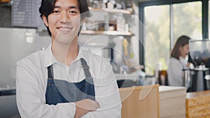 Young man confident cafe owner standing crossed arms on front counter bar at the cafe coffee shop