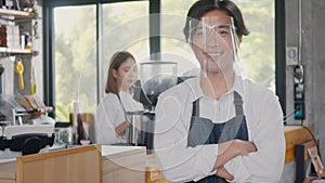 young man confident cafe owner standing crossed arms on front counter bar at the cafe coffee shop