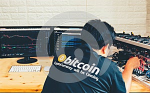 A young man configures hardware for bitcoin mining photo