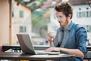 Young man connecting with a laptop at the bar