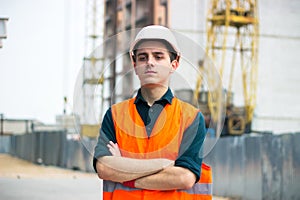 Young man in construction in orange vest