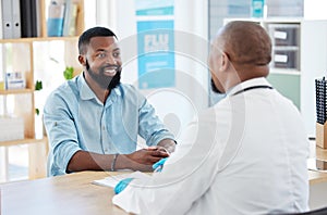 Young man in consult with his doctor. African man talking his gp in a checkup. Confident man talking to a medical