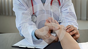 A young man consulted a doctor With a wrist injury in the office at the doctor`s desk