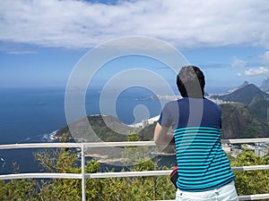 Young man contemplating the ocean. Travel, thinking and relaxation concept.