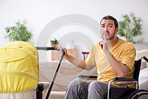 Young man contractor in wheel-chair looking after newborn