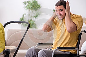 Young man contractor in wheel-chair looking after newborn