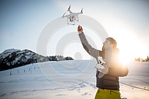 Young man controlling his drone in snowy outdoors