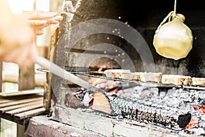 Young man cooking caciocavallo cheese with bread in barbecue dinner - Chef grilling special italian dish for bbq - Concept of