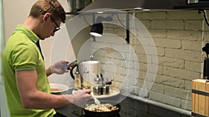 Young man cooking and surfing internet