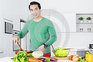 Young man cooking vegetable