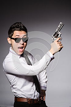 Young man in cool sunglasses holding gun