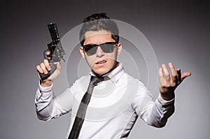 Young man in cool sunglasses holding gun