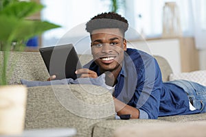 young man on couch with tablet