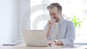 Young Man Coughing while using Laptop