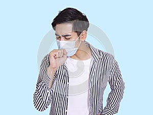 Young man coughs and wears a protective medical mask to prevent infection