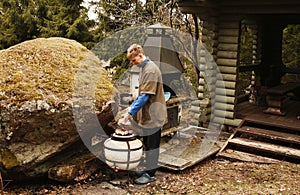 young man in a country dacha prepares meat on the grill