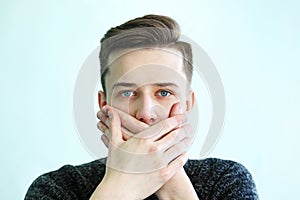 Young man covered mouth with hands