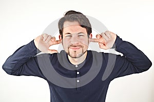 young man covering ears from loud noise, isolated on white background