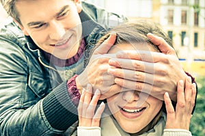 Young man covering the eyes of an happy surprised girlfriend