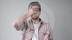 Young man covering his face by hand and peeping at the end.