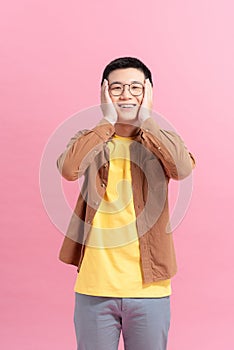 Young man covering his face and smiling