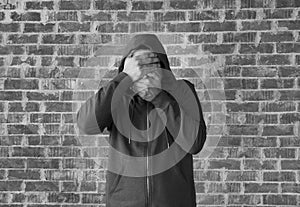 Young man covers his eyes and mouth with hands ,black and white