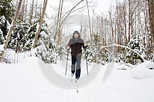 Young man cross-country skiing in the forest