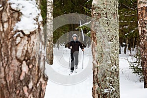 Young man cross-country skiing in the forest