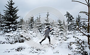 Young man cross-country skiing through snowy alpine landscape