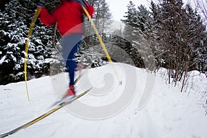Young man cross-country skiing on a snowy forest trail