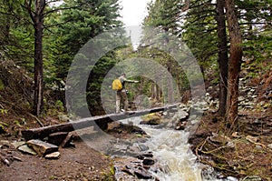 Young man crossing a stream