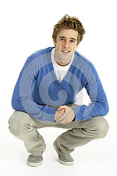 Young Man Crouching In Studio photo