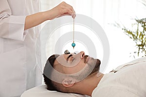 Young man during crystal healing session in room