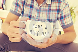 Young man with a cup with the text have a nice day