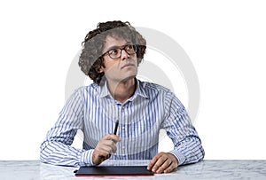 Young man with curly hairs sitting at the desk in front of graph