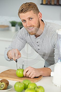 young man cutting apples preparing apple juice