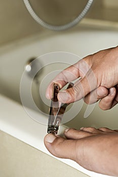 Young man cutting his toenails