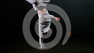 Young man dancer spinning around on one hand and keeping the balance