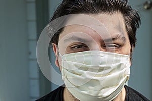 Young man with dark hair in face mask for protection