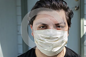 Young man with dark hair in face mask for protection