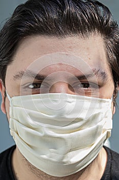 Young man with dark hair in face mask for protection