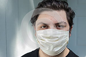 Young man with dark hair in face mask for protection