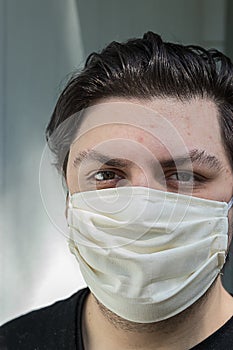 Young man with dark hair in face mask for protection