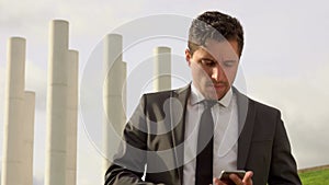 A young man in a dark suit speaks on the phone