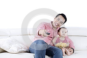 Young man and daughter watching TV