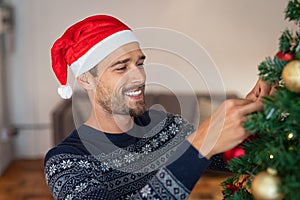 Young man decorating christmas tree